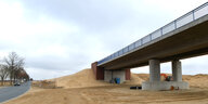 eine im Bau befindliche Autobahnbrücke neben Sandbergen