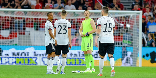 Vier deutsche Nationalfußballer - Kehrer, Schlotterbeck, Neuer und Süle - stehen ratlos auf dem Rasen