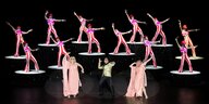 Das farbenfroh kostümierte Revue-Ensemble vollführt in der Komischen Oper Berlin eine Choreographie.