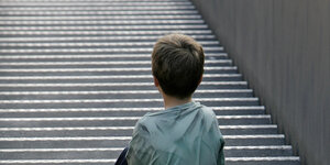 Ein Junge sitzt auf einer Treppe