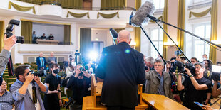 Eine Person von hinten bei einer Pressekonferenz.