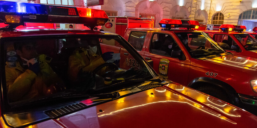 Feuerwehrleute in Feuerwehrfahrzeugen.