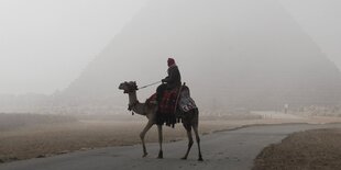 Reiter auf einem Kamel vor einer Pyramide