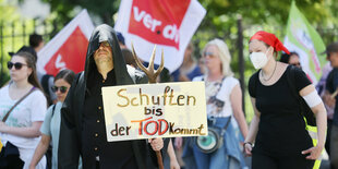 Demonstration mit Plakaten und Fahnen.