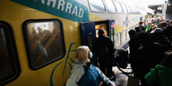 Menschen mit Fahrrädern stehen vor der Zugtür eines Metronoms