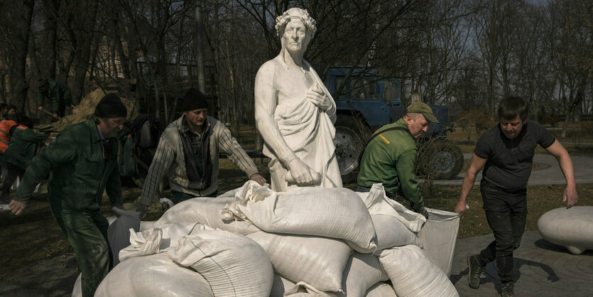 Eine Statue wird mit Sandsäcken geschützt.