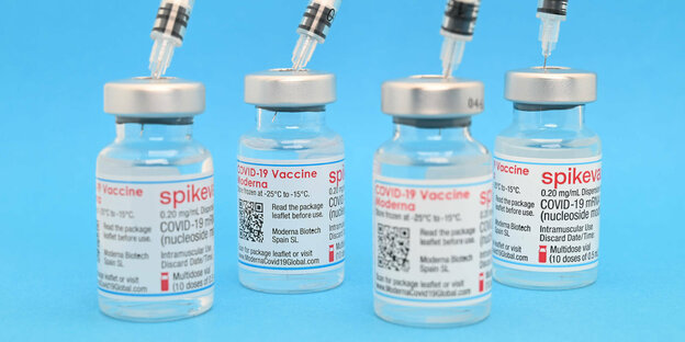 Spritzen stecken in Impfdosenfläschen.