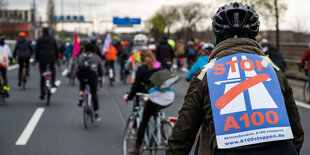 Radler*innen fahren mit Protestschildern gegen die A 100