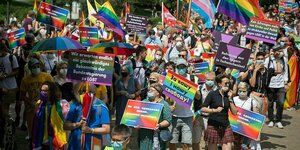 Eine Menschenmenge mit Fahnen und Plakaten in Regenbogenfarben