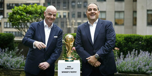 Gianni Infantino und Vittorio Montagliani stehen neben dem auf einem Sockel postierten WM-Pokal