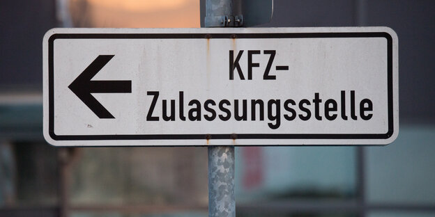 Ein Hinweisschild mit der Aufschrift "KfZ-Zulassungsstelle" und einem Pfeil.