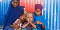 Ein Junge in Somalia mit seinern Schwestern und seiner Mutter