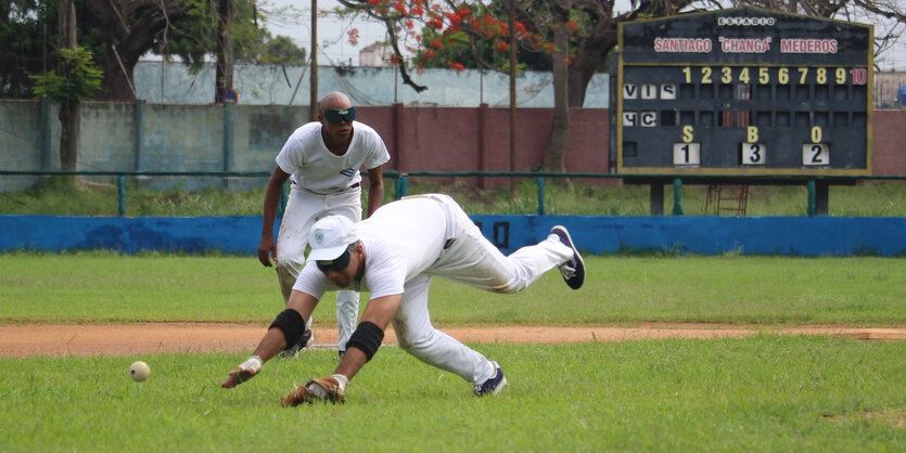 Zwei Menschen mit Augenbinde versuchen einen Baseball zu fangen