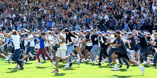 Viele Fans stürmen auf die Rasenfläche im Marschweg-Stadion