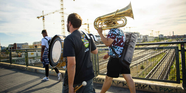 Musiker tragen am 21.06.2017 im Rahmen der Fete de la Musique in Berlin ihre Instrumente über die Warschauer Brücke.