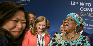 Drei Frauen lachen auf einer Konferenz