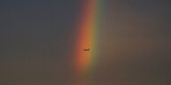 Ein Flugzeug fliegt durch einen Regenbogen