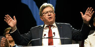 der linke französische Politiker Mélenchon redet an einem Pult