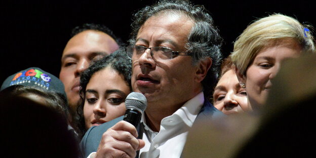 Gustavo Petro spricht in ein Mikro, umgeben von Anhänger:innen