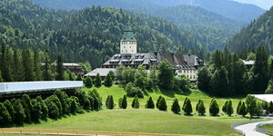 Blick auf das idyllisch gelegene Schloss Elmau vor Bergkulisse