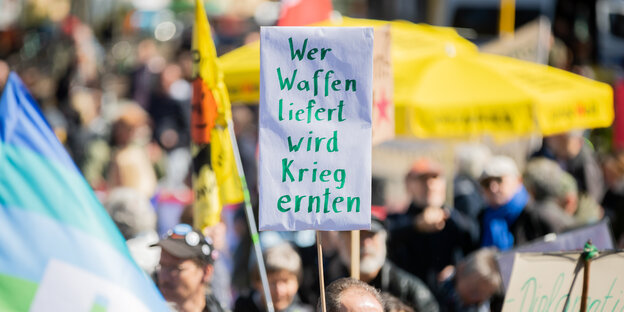 Eine Demo mit einem Schild mit der Aufschrift: Wer Waffen liefert wird Krieg ernten