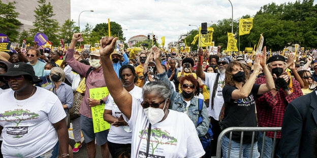 Eine Menschenmasse demonstriert mit gelben Plakaten