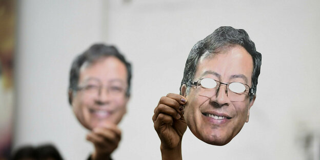 Anhänger von Gustavo Petro halten Masken mit seinem Portrait in die Höhe