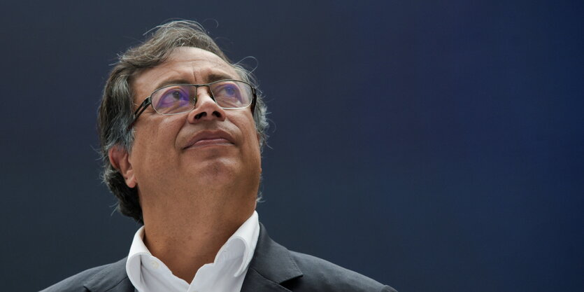 Gustavo Petro vor blauem Himmel, er schaut nach oben