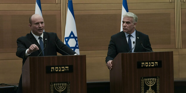 Naftali Bennett und Jair Lapid stehen nebeneinander an Redepulten