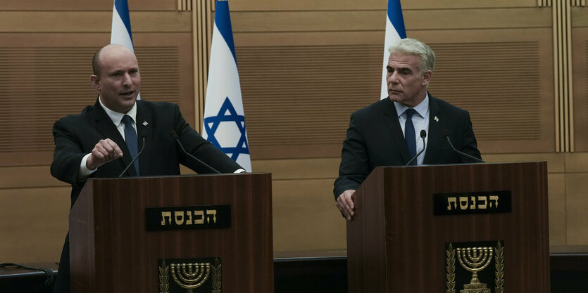 Naftali Bennett und Jair Lapid stehen nebeneinander an Redepulten