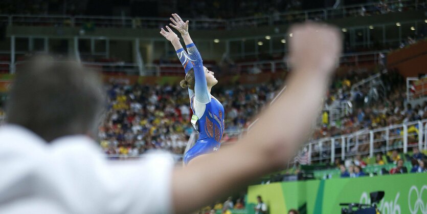 Sanne Wevers aufrecht und mit gestreckten Armen nach ihrer olympischen Turnübung am Schwebebaklen