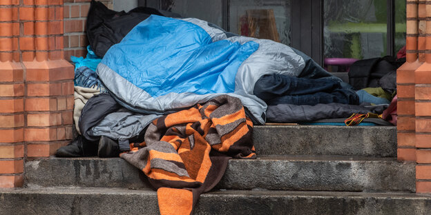 Obdachloser Mensch am Kircheneingang