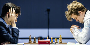Magnus Carlsen und Alireza Firouzja nachdenklich vor dem Schachbrett