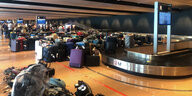 Hamburger Flughafen von innen mit vielen Koffern und ein paar Menschen an den Gepäcklaufbändern