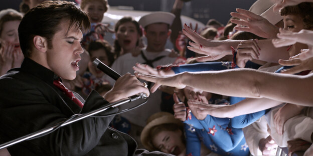 Eine Szene aus dem Film "Elvis" in denen die Fans mit ihren Armen versuchen den Elvis Darsteller zu berühren.