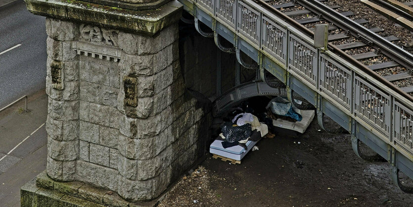 Matratzen als Schlafstädte unter der Brücke einer Hochbahn