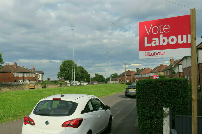 Vor einem Haus steht ein Schild der Labour-Partei