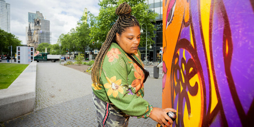 Eine Frau sprüht auf eine Wand