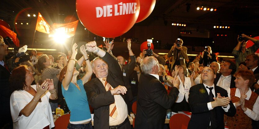 Menschen feiern unter einem roten Luftballon mit der Aufschrift Die Linke