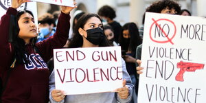Frauen demonstrieren mit Plakaten auf denen Slogans gegen Waffengewalt stehen