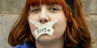 Eine Demonstrantin hat sich mit einem beschrifteten Klebeband "219a" den Mund zugeklebt