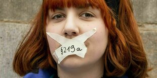 Eine Demonstrantin hat sich mit einem beschrifteten Klebeband "219a" den Mund zugeklebt