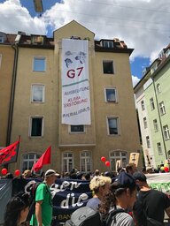 Banner an Hauswand: G7 Ausbeutung Kima-Zerstörung, Imperialismus Banner an Hauswand: G7 Ausbeutung Kima-Zerstörung, Imperialismus