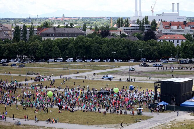 große Wiese, Bühne, davor wenige Menschen - Luftbild