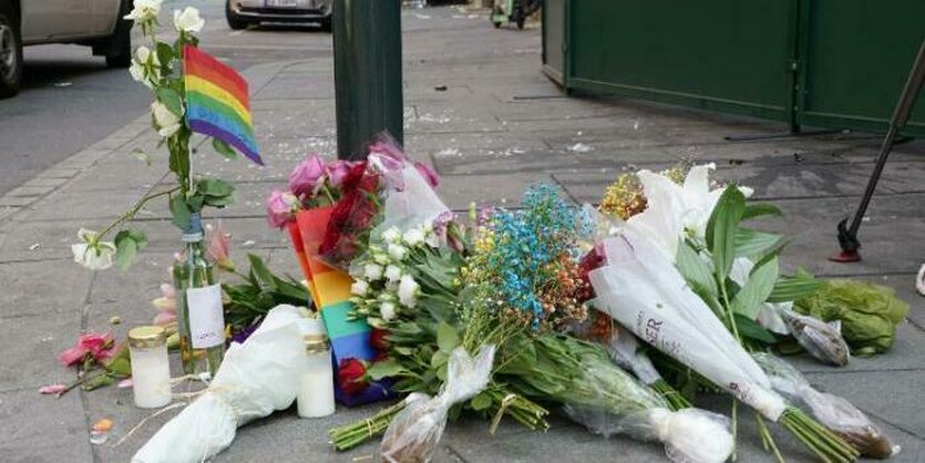 Blumen und Regenbogenfähnchen liegen am Tatort