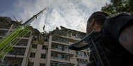 Ein Mann beobachtet ein zerstörtes Wohnhaus