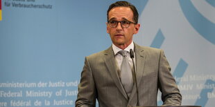 Heiko Maas hinter einem Mikrophon