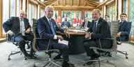 Bundeskanzler Olaf Scholz, US-Präsident Joe Biden der britische Premier Boris Johnson und die anderen Staats- und Regierungschefs der G7 blicken an einem Tisch sitzend in die Kamera