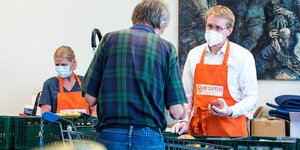 Schleswig-Holsteins Ministerpräsident Daniel Günther hilft bei der Ausgabe von Lebensmitteln bei der Husumer Tafel.
