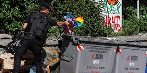 Ein Polizist wirft in Istanbul eine Regenbogenfahne in eine Mülltonne
